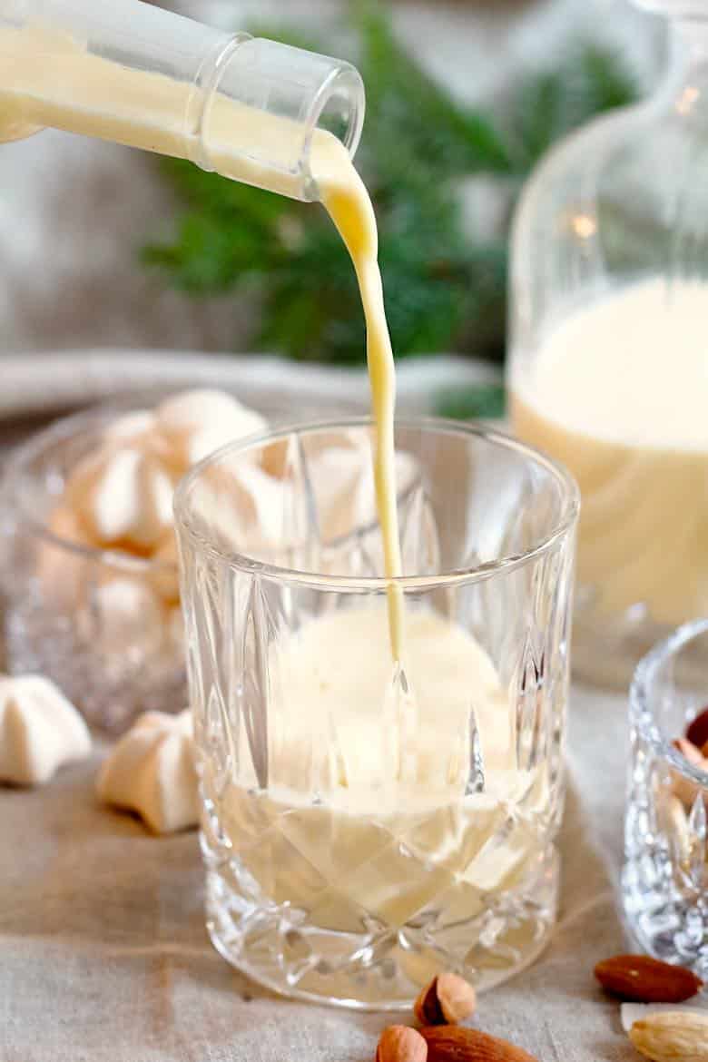 Homemade Almond Milk Keto Eggnog Recipe beeing poured into the whisky glass