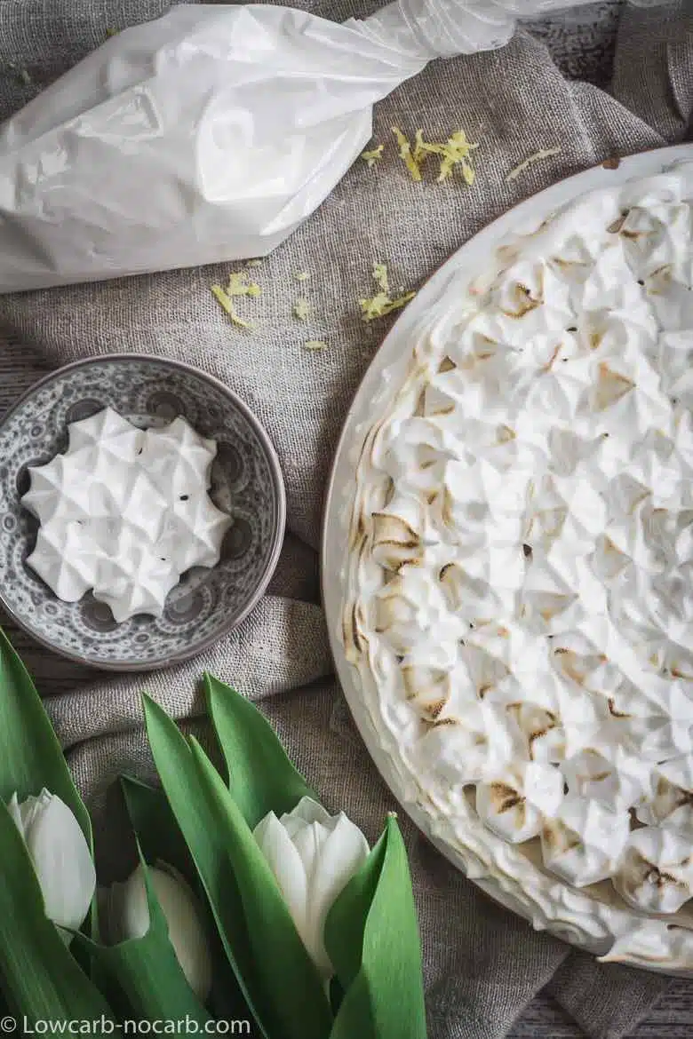 Keto Instant Pot Lemon Cheesecake with Sugar-Free Swiss Meringue Icing rustic look with white tulips