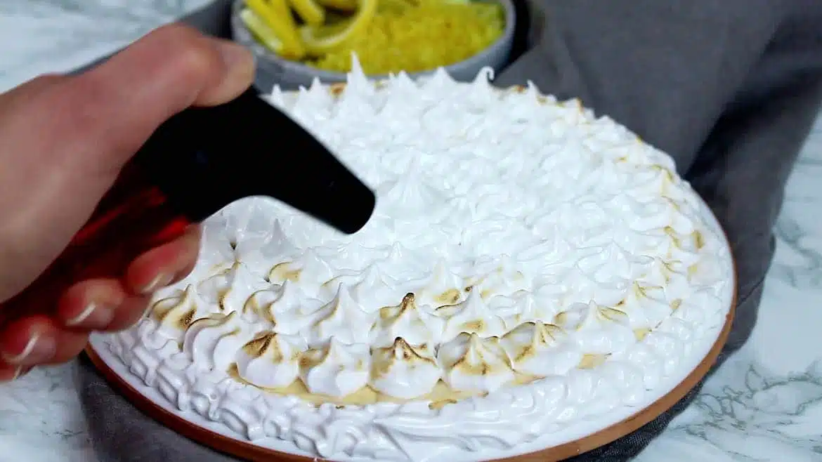 Keto Instant Pot Lemon Cheesecake with Sugar-Free Swiss Meringue Icing step using the torch to brown the icing