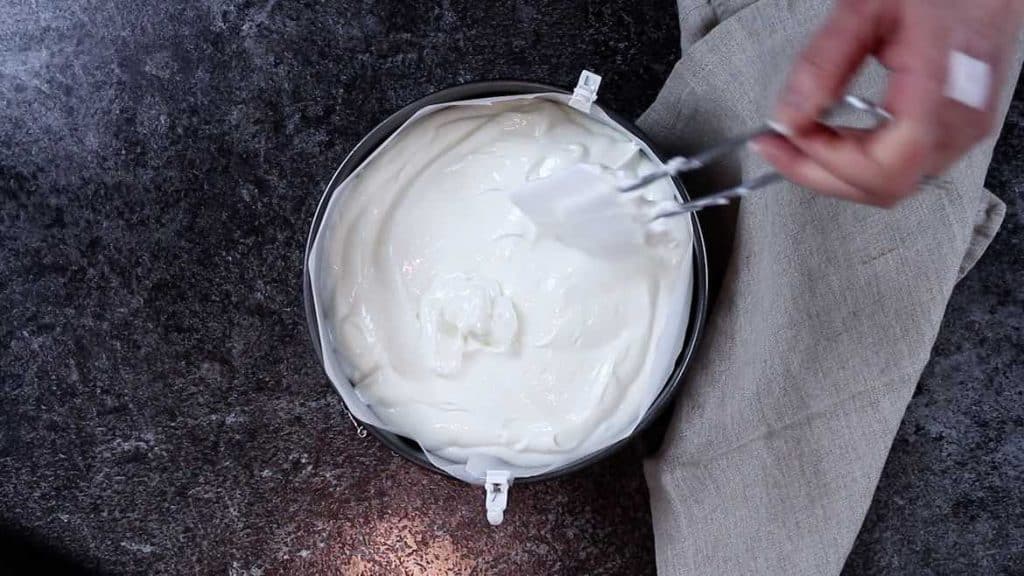Placing yogurt cheesecake mixture into the baking dish