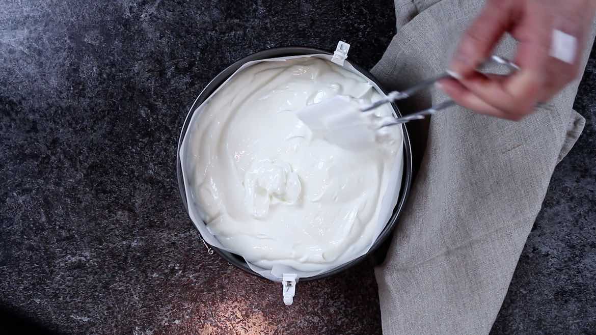 Placing yogurt cheesecake mixture into the baking dish