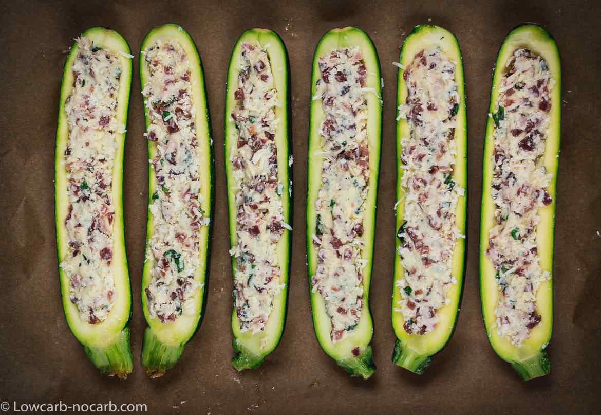 raw Keto Bacon Zucchini Boats filled with cheese mixture