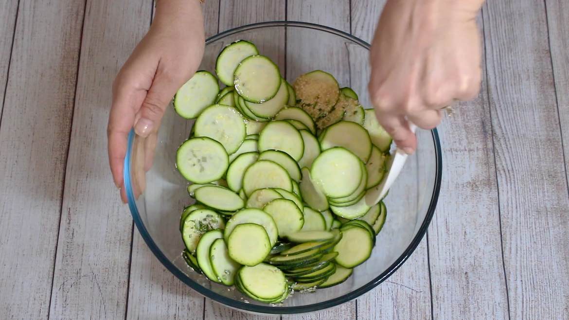 mixing zucchini chips slices with seasoning