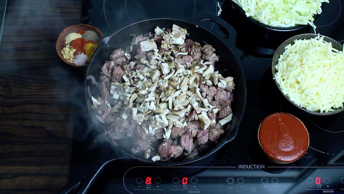 Cheesy Cabbage Beef Keto Casserole mushrooms being added into the skillet