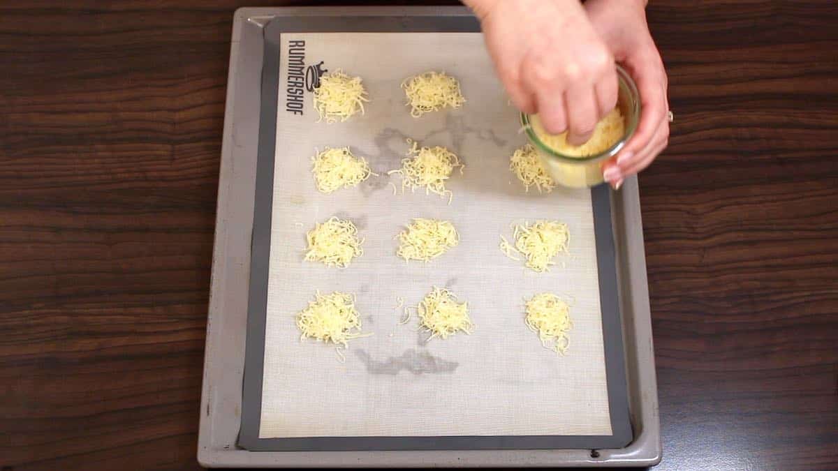 placing grated cheese on a baking sheet