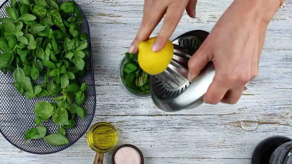 Basil Pesto Without Nuts pouring lemon juice in
