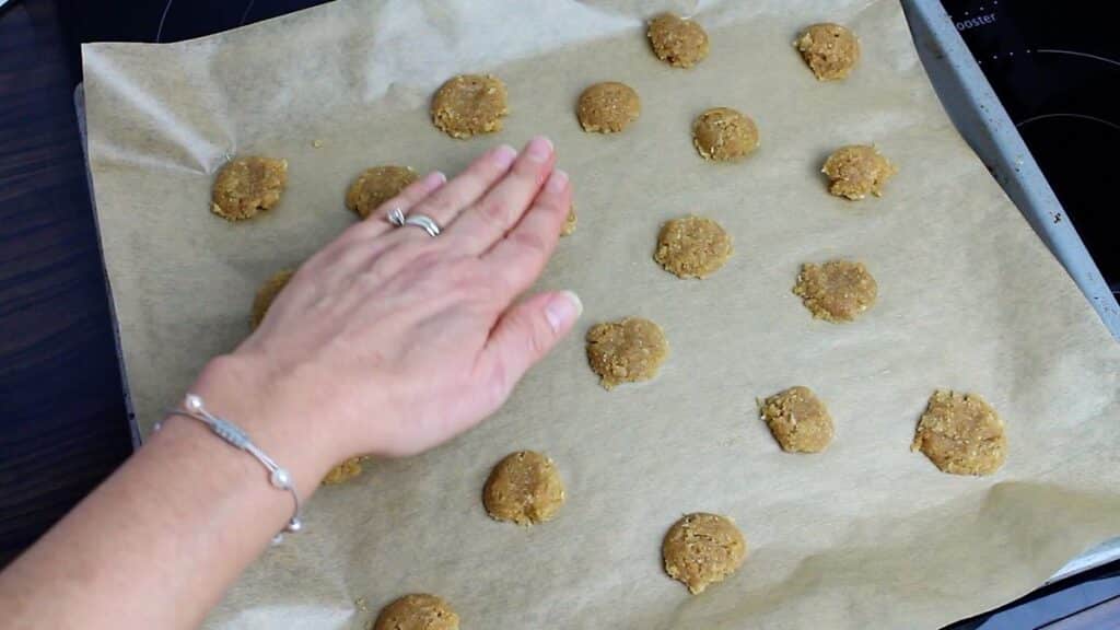Low Carb Butter Cookies pressing with hand on a baking tray