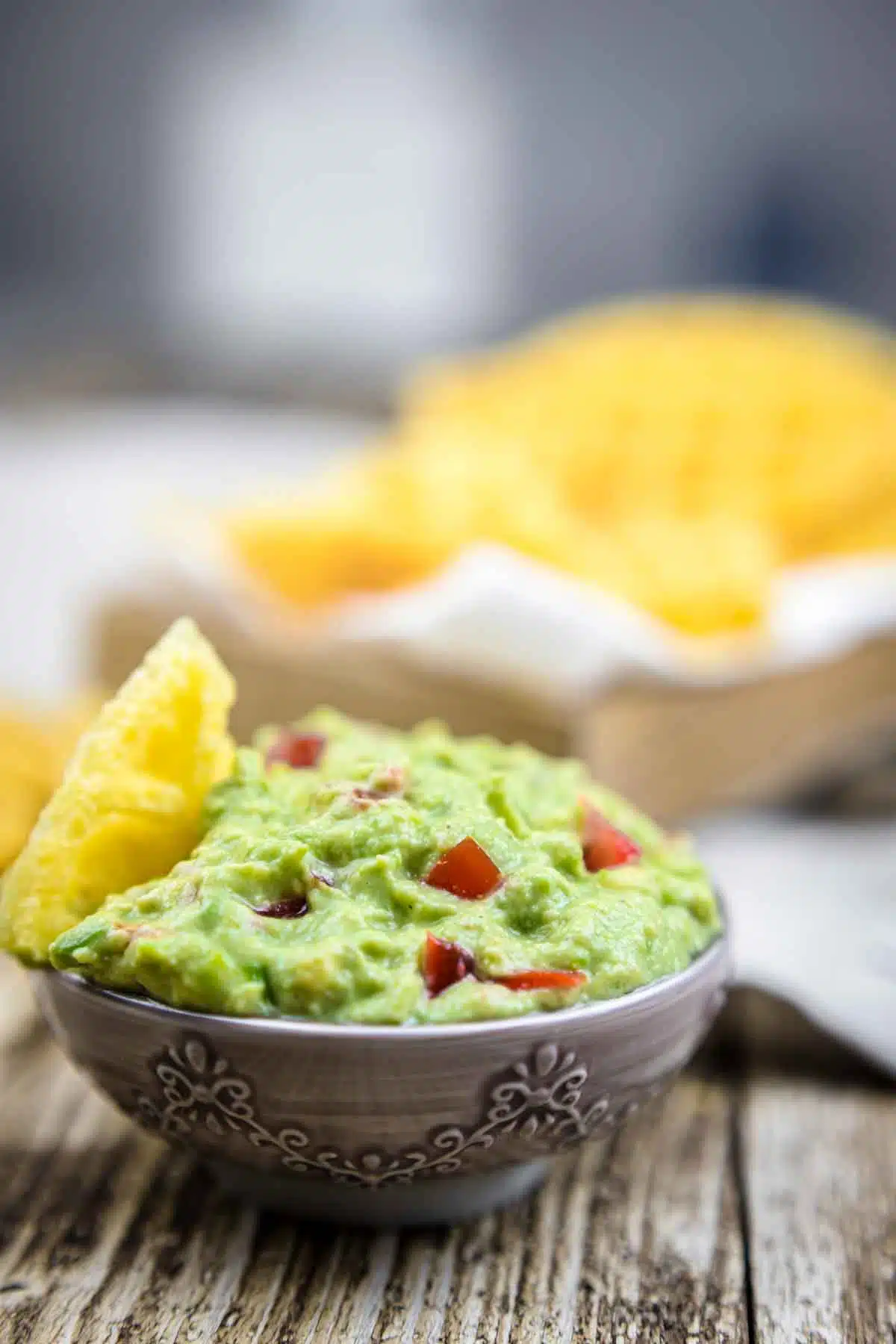 Keto Avocado Dip in a bowl with chips behind