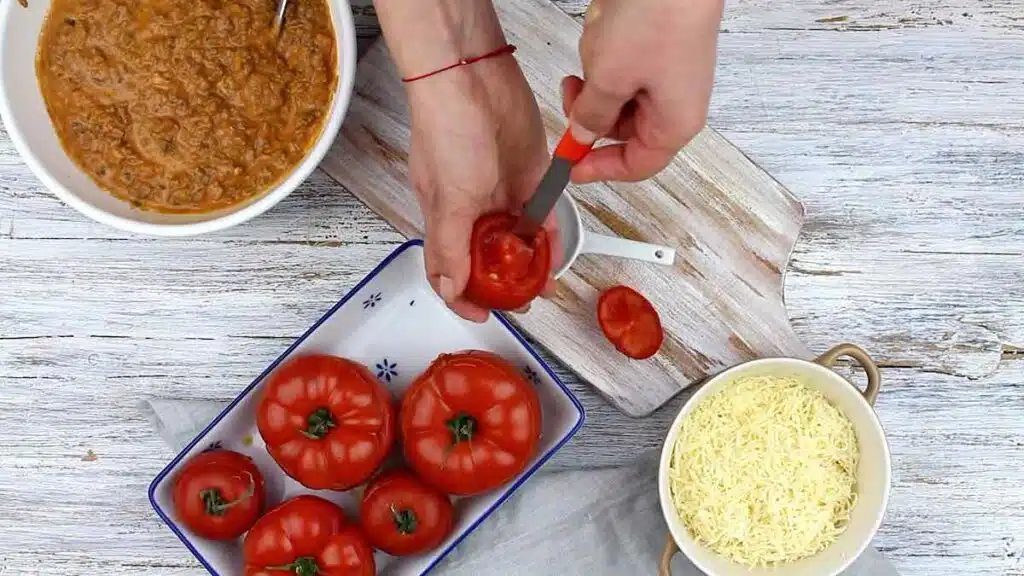 Stuffed Tomatoes with Ground Meat and Cheese cutting inside the tomatoes
