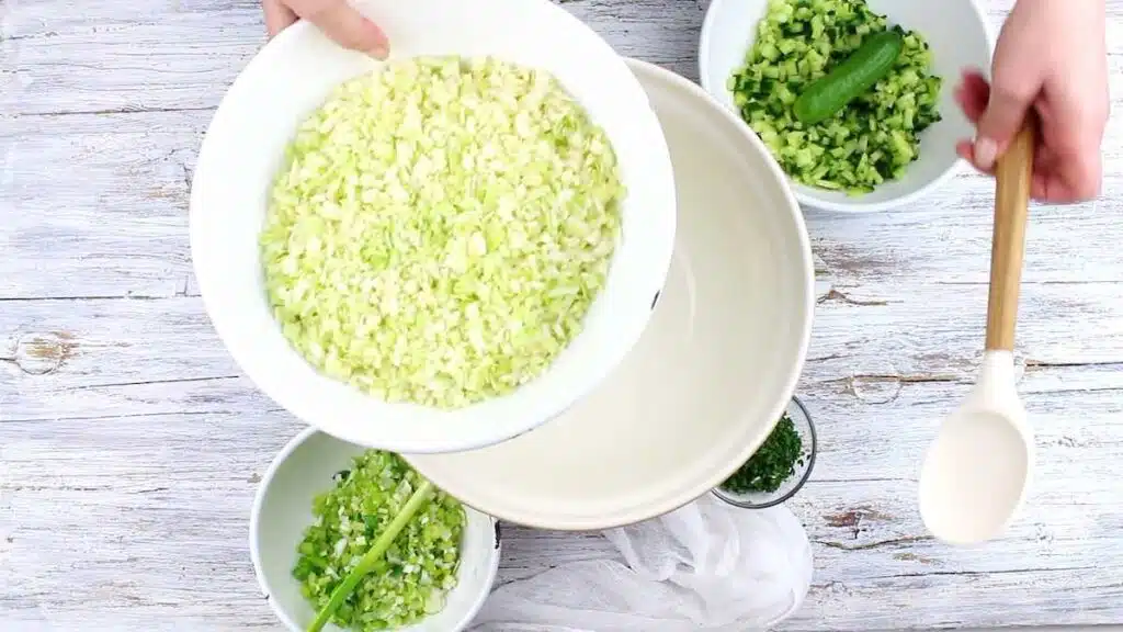 green goddess salad recipe tiktok placing cabbage into the mixing bowl.