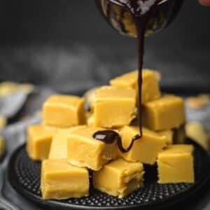Sugar Free Peanut Butter Fudge pouring chocolate over.