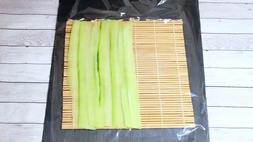 Keto Sushi Rolls layering cucumber slices.