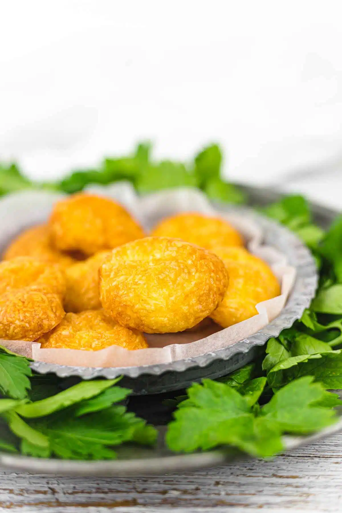 Cheese Puffs Air fryer on a parchment paper covered bowl.