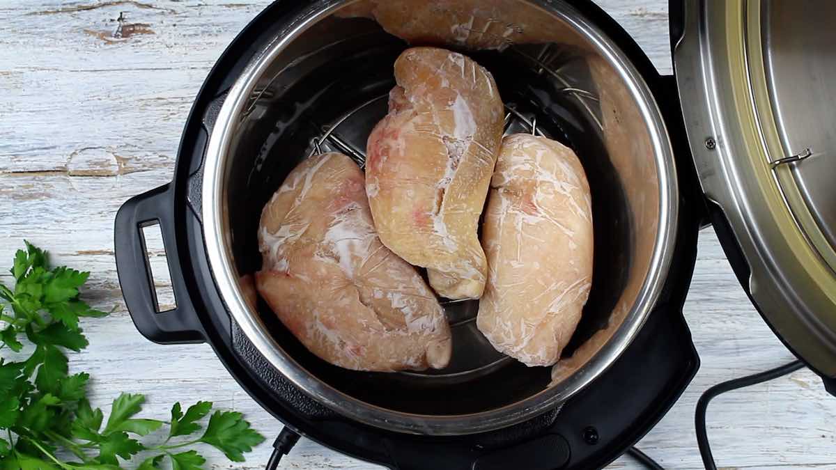 Frozen Chicken Breast in Instant Pot adding onto the pot.
