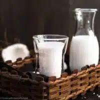 glass and a jar of coconut milk inside a basket.