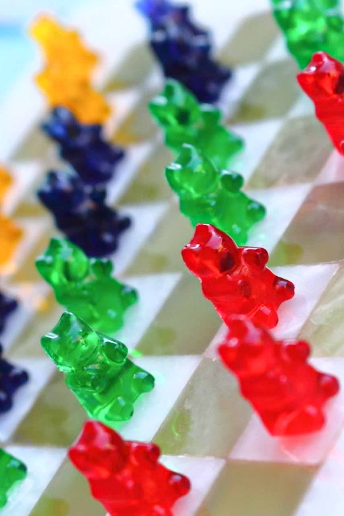 colorful gummy bears standing on a checkered board.