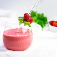 strawberry smoothie in a glass with straw.
