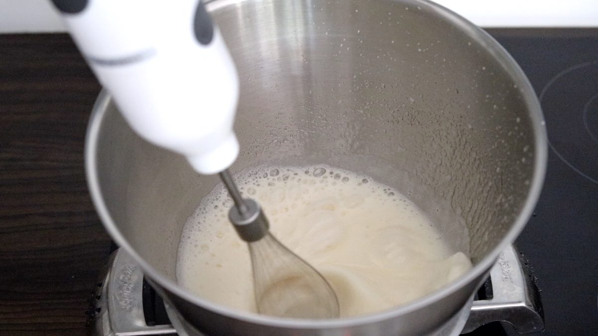 keto frosting recipe whisking in a double boiler.