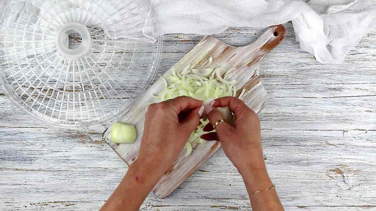 How To Dehydrate Onions splitting slices.