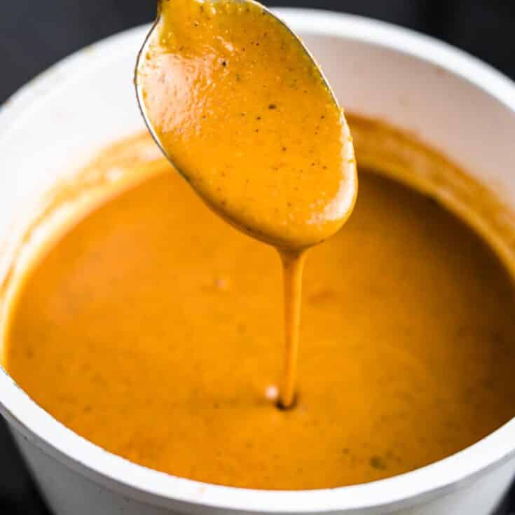 Make keto enchilada sauce pouring from spoon.