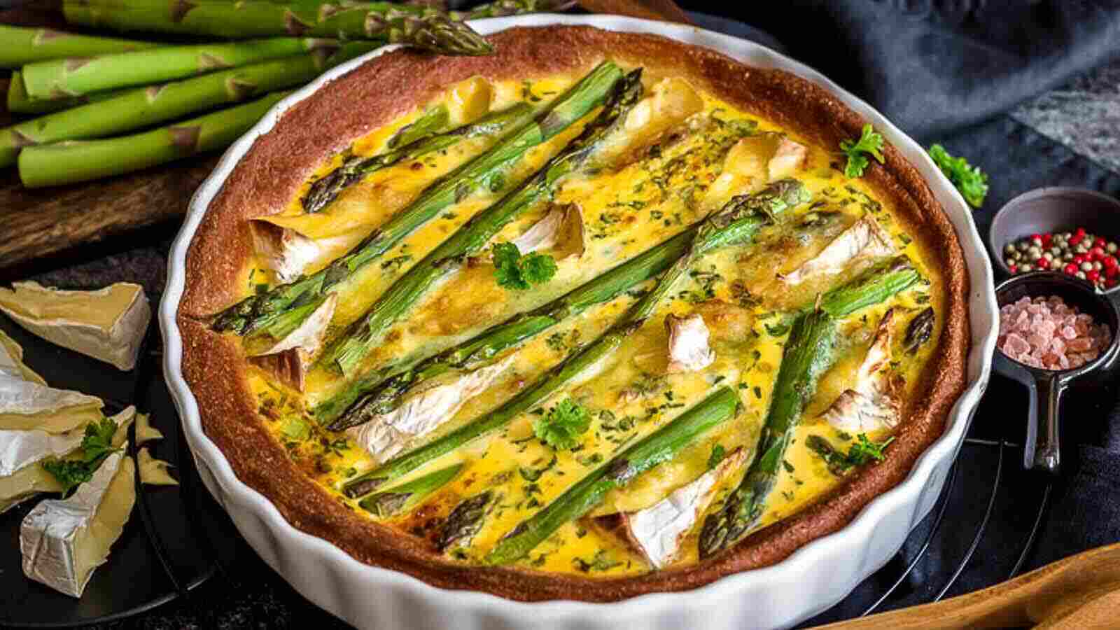 A quiche with asparagus and cheese inside casserole.