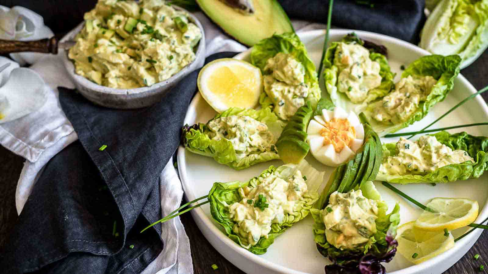 A plate with lettuce wraps and avocado on it.