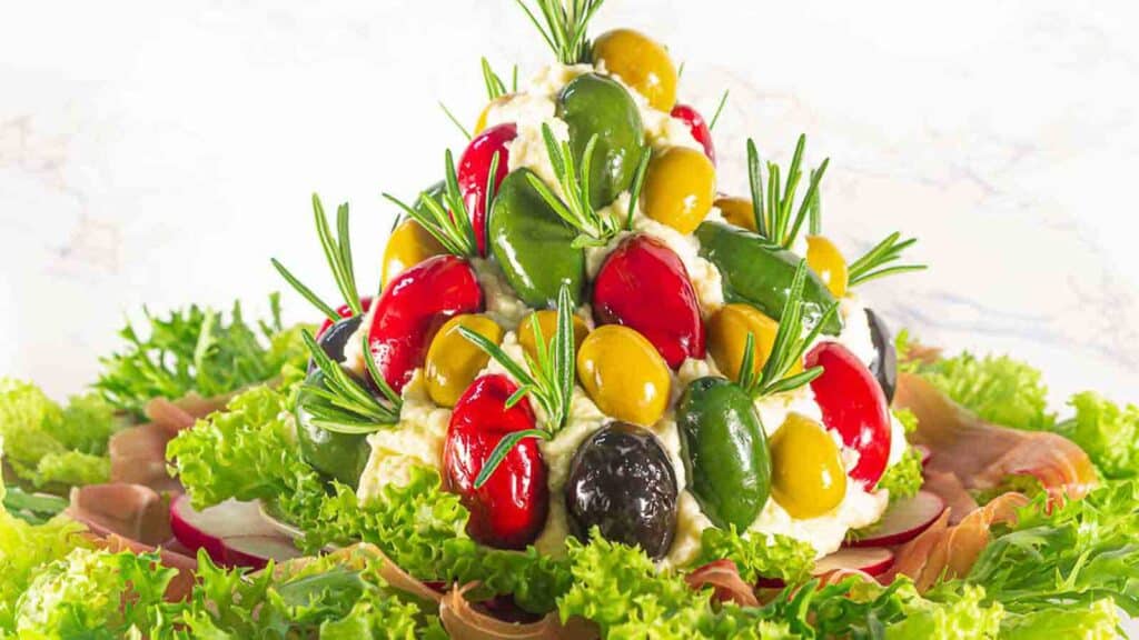 A spread with olives and other vegetables on top of a plate.