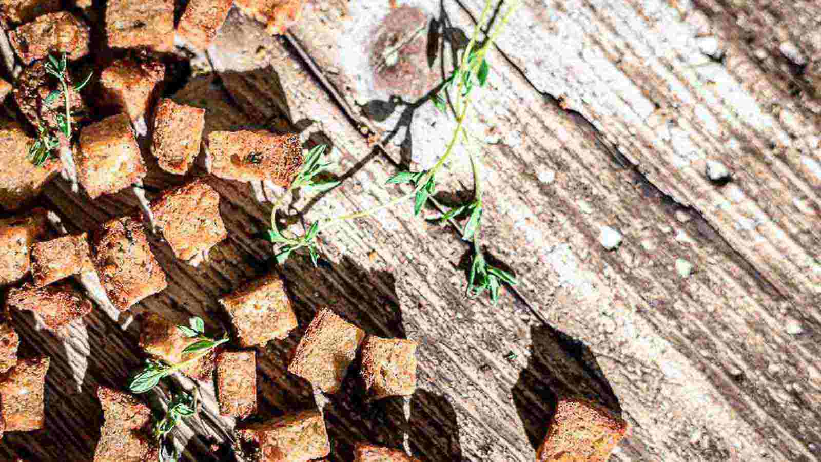 Croutons on a wooden table with sprigs of thyme.