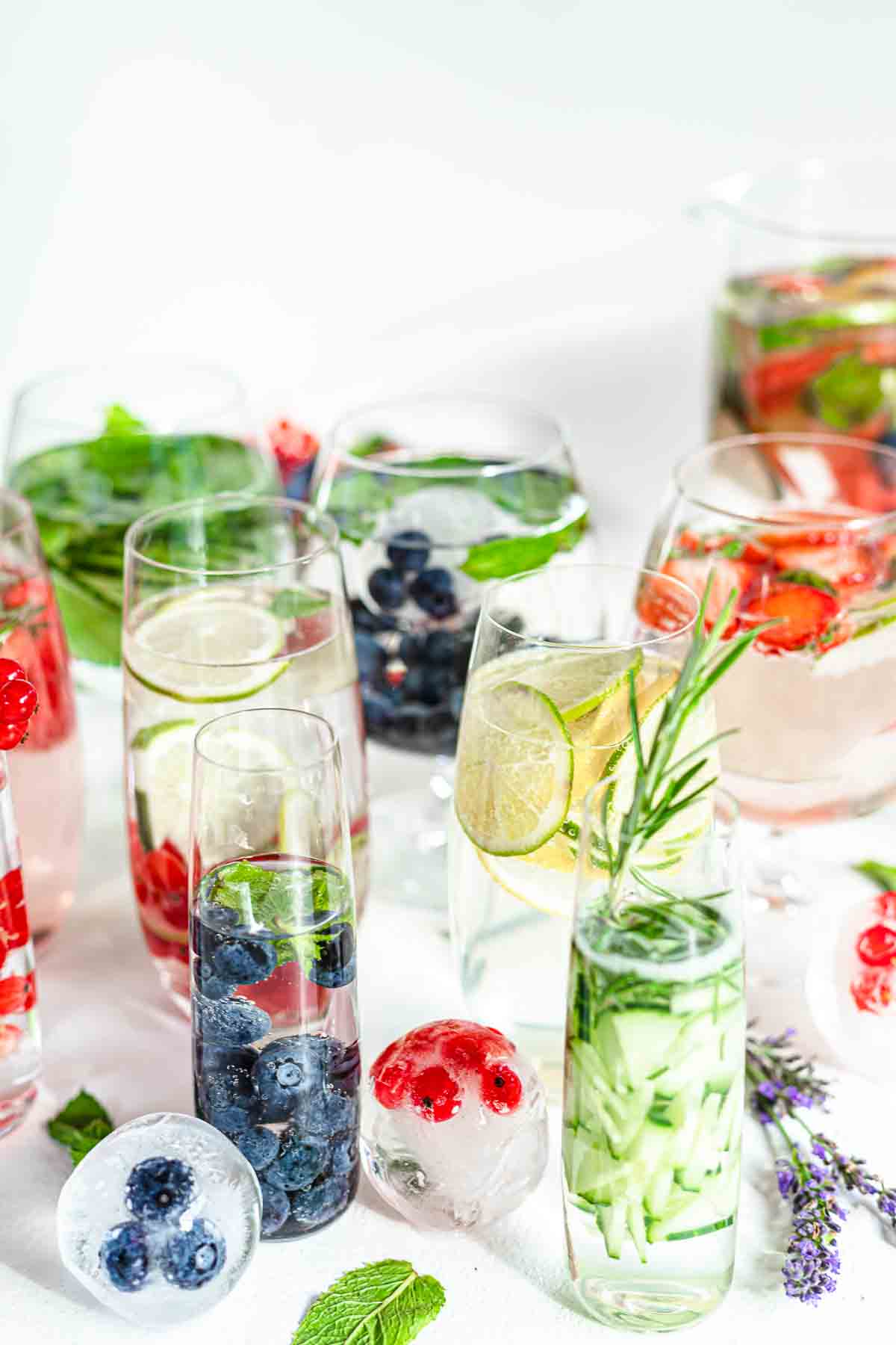 A group of glasses filled with fruit and ice.