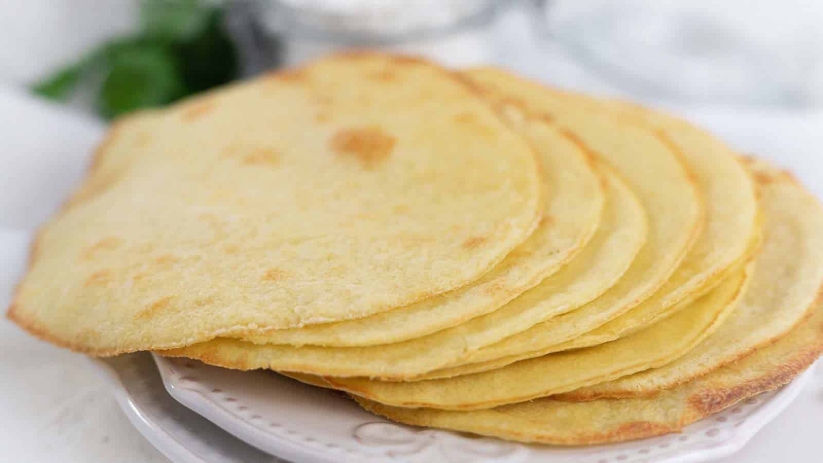 A stack of gluten free flatbreads on a white plate.
