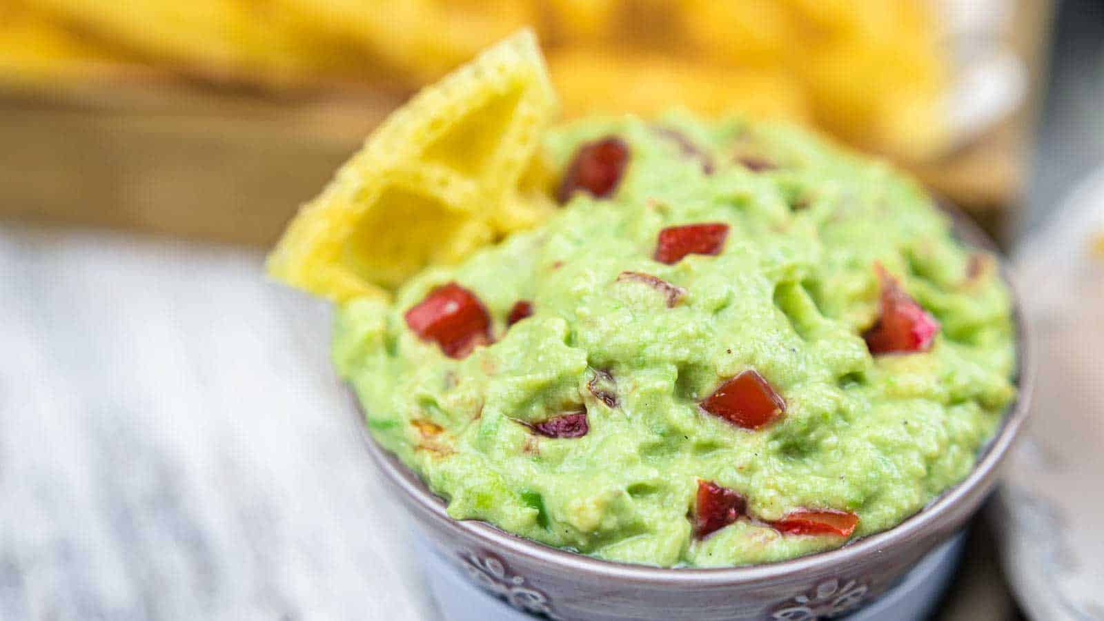 Guacamole Dip with Sour Cream in a bowsl with chips.