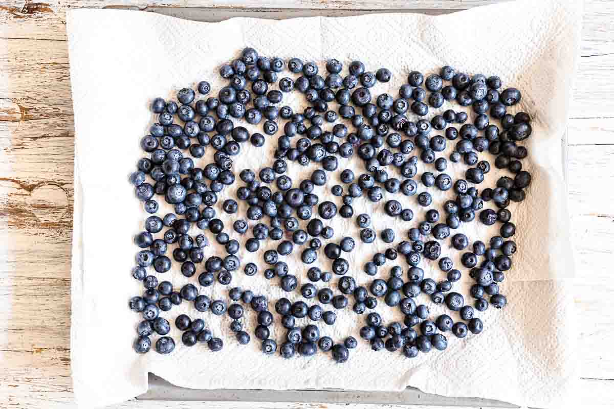 Blueberries on a baking sheet on a wooden table.