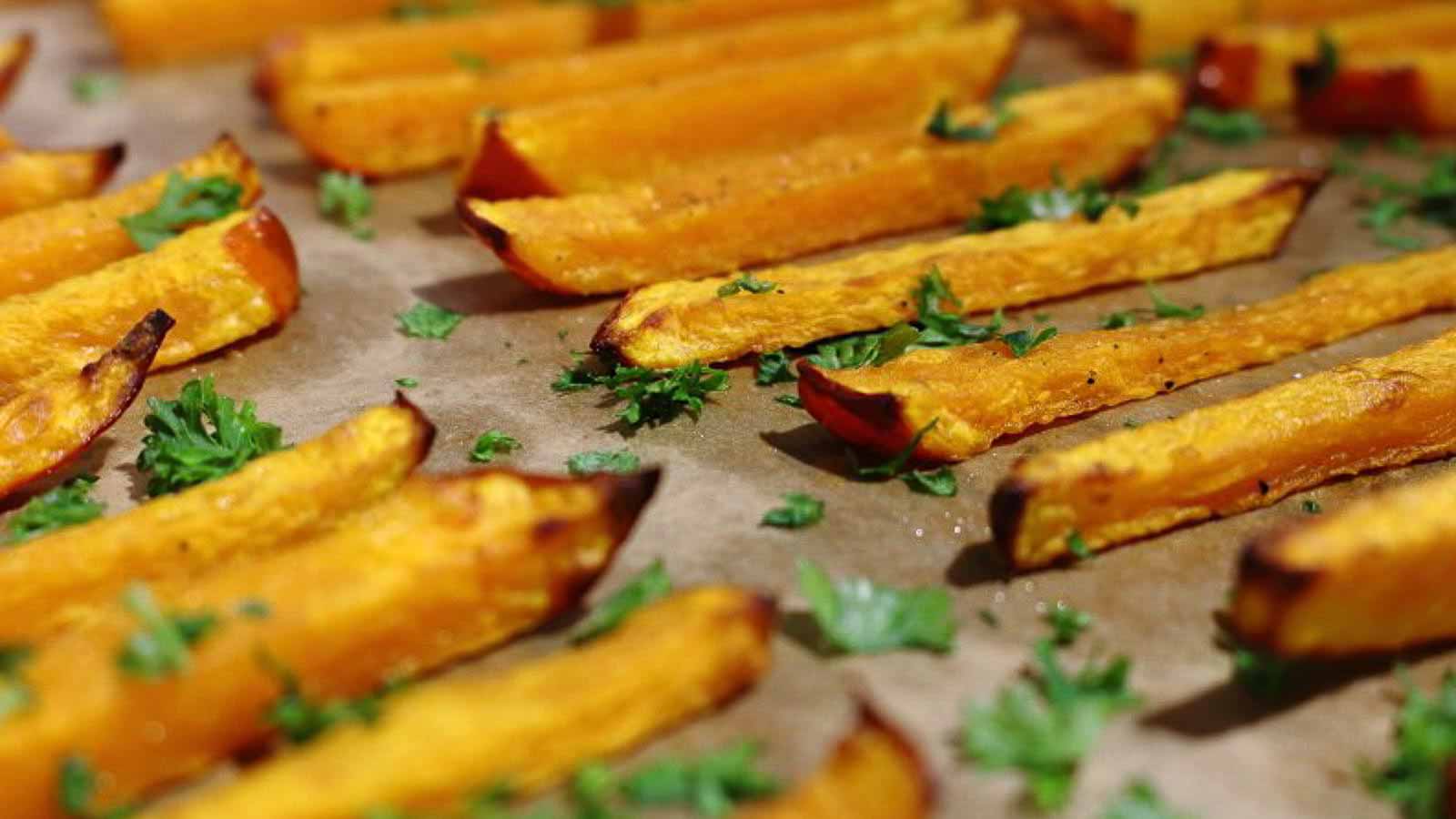 Pumpkin Fries on a parchment paper with herbs. 