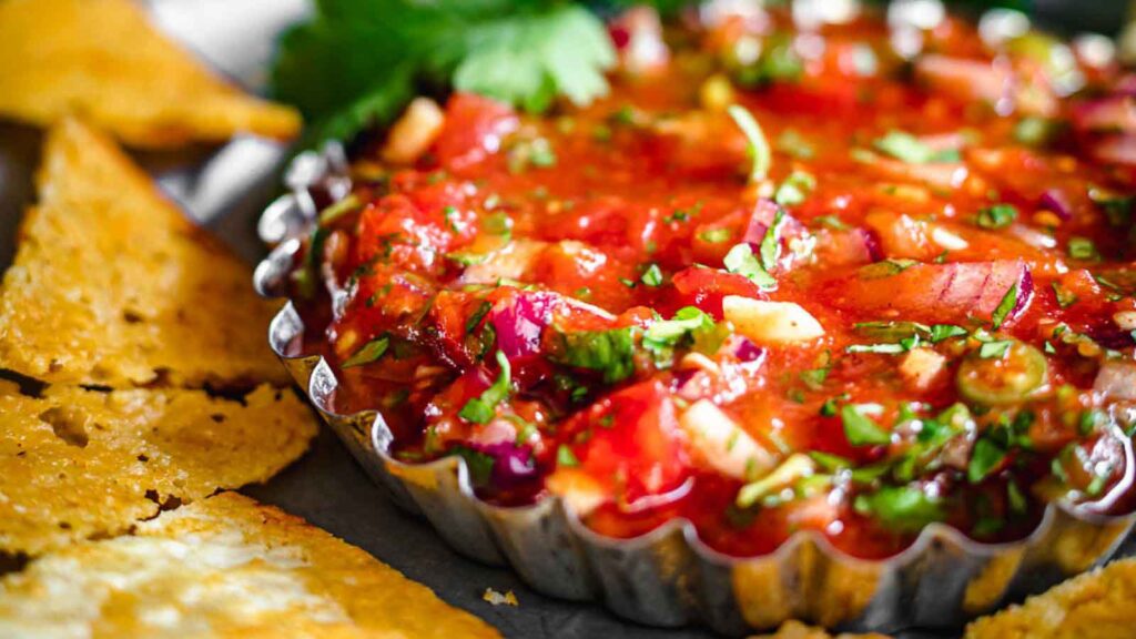 Mexican salsa with tortilla chips on a plate.