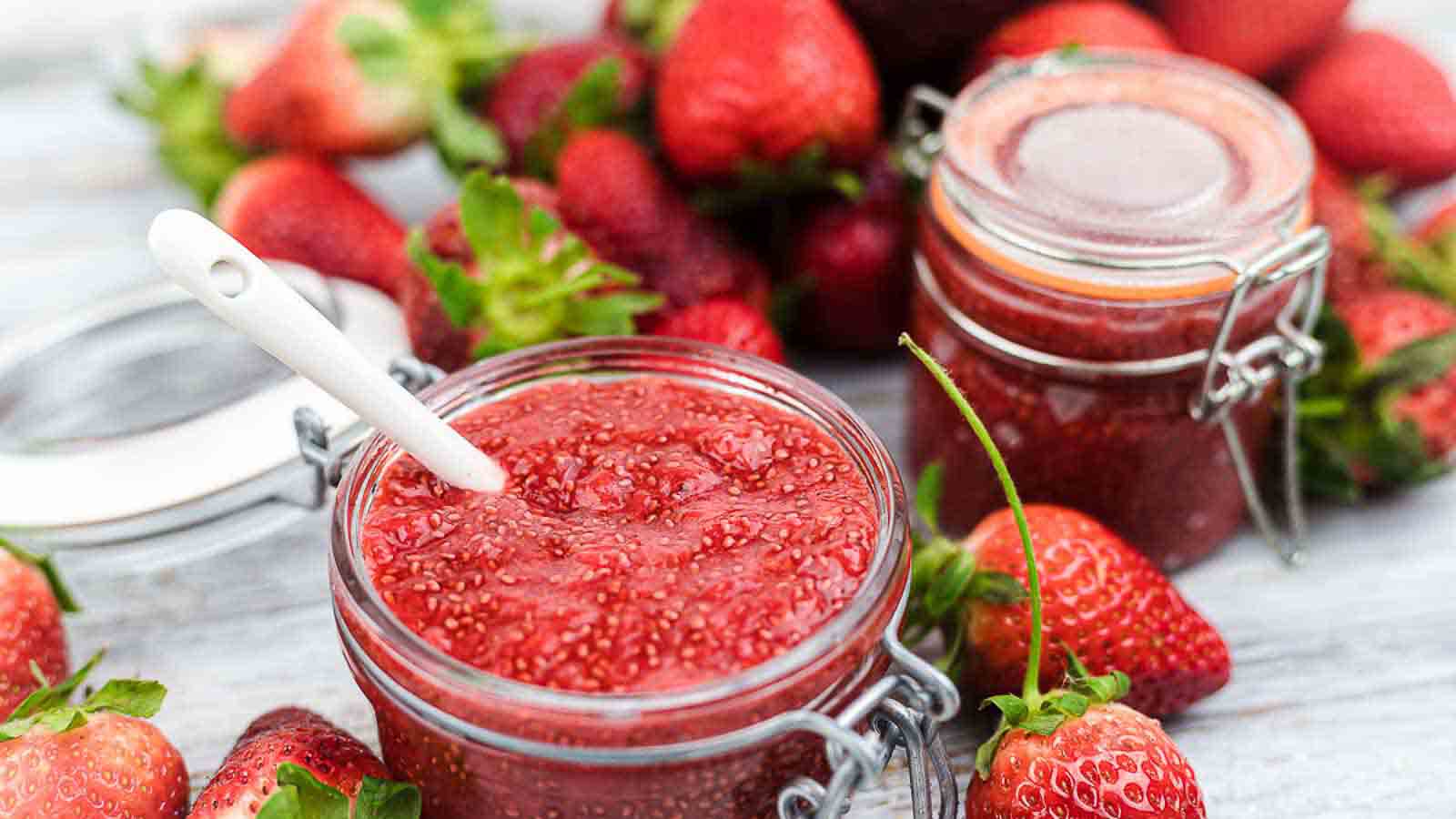 Strawberry jam in jars with a spoon.