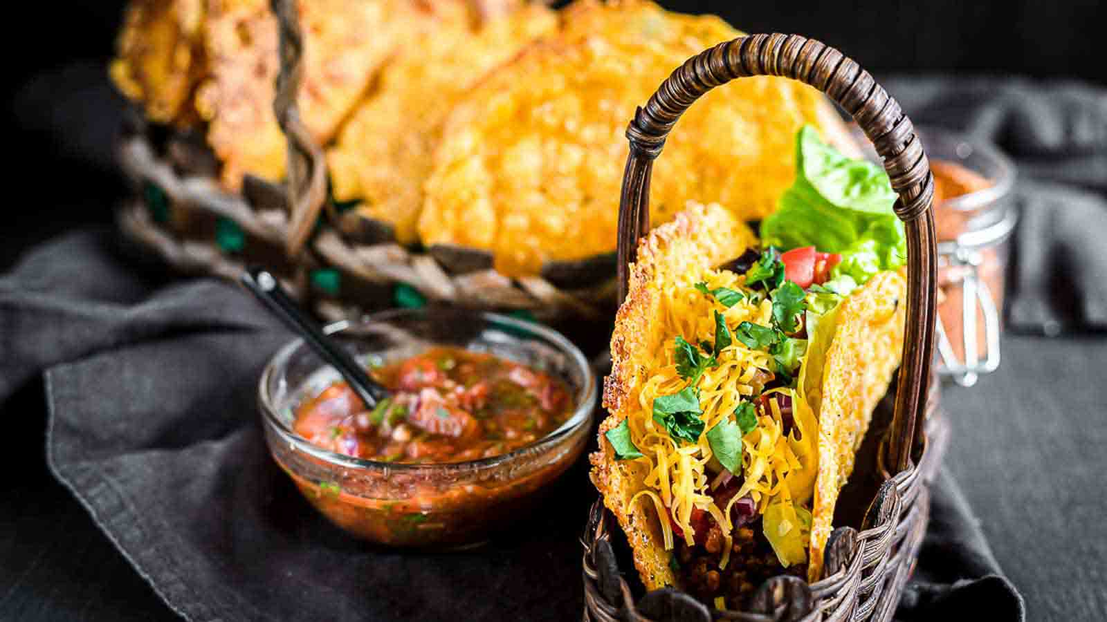 Mexican tacos in a basket with salsa and guacamole.