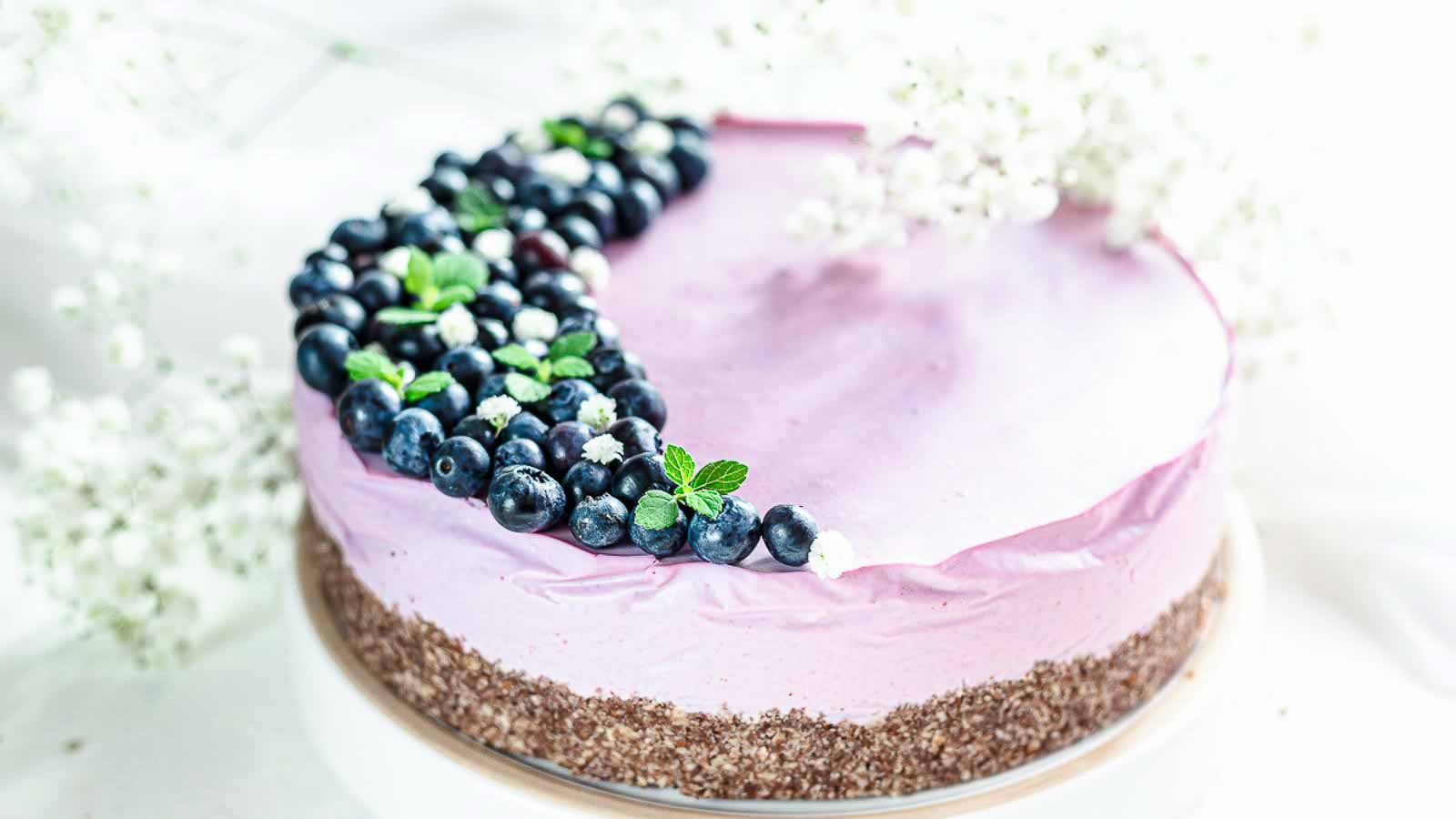 A pink cake with blueberries on top.