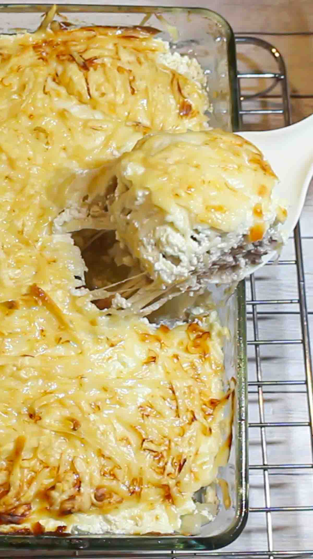 A casserole dish with a scoop of cheese on top.