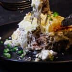 A plate of meat and cheese with a fork.
