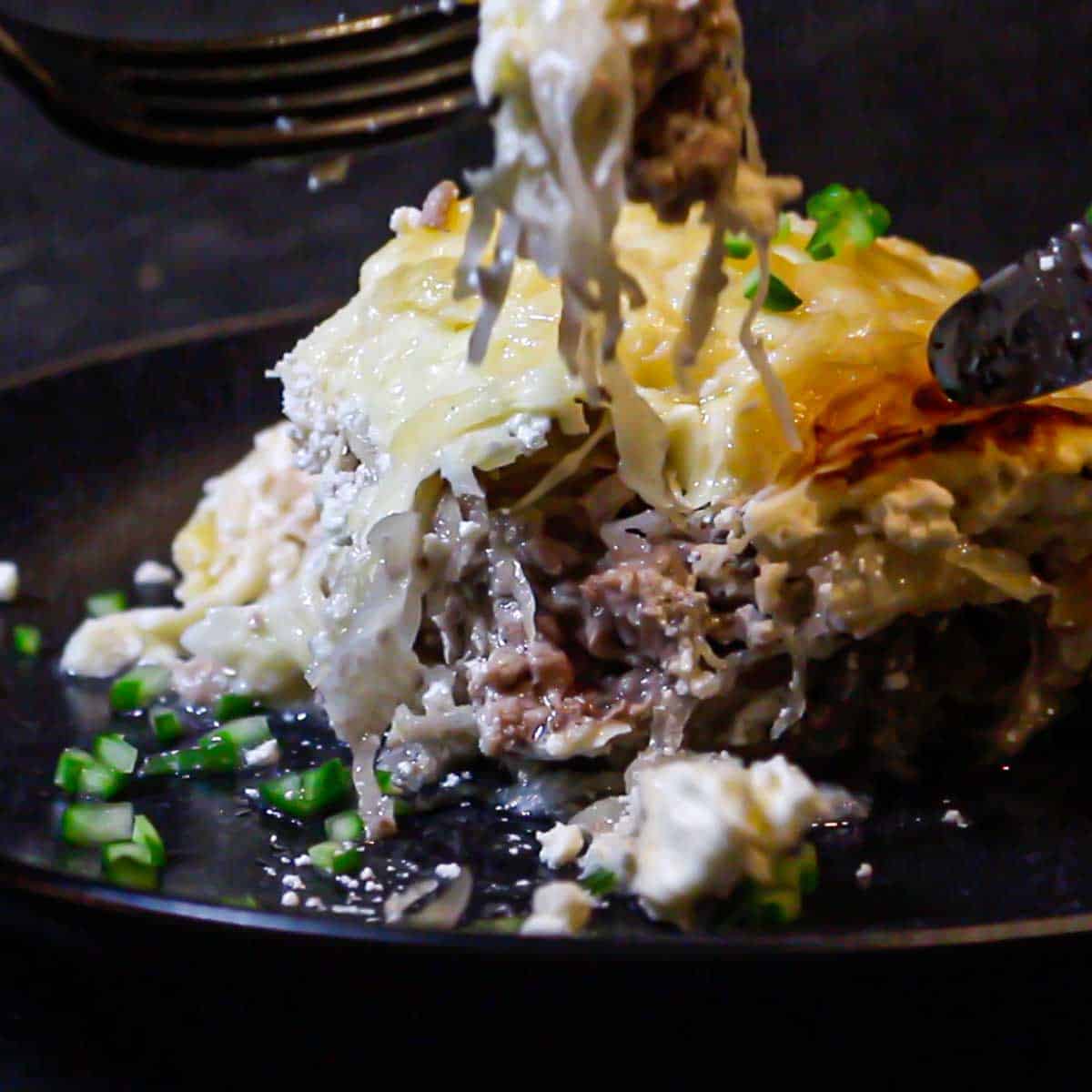 A plate of meat and cheese with a fork.