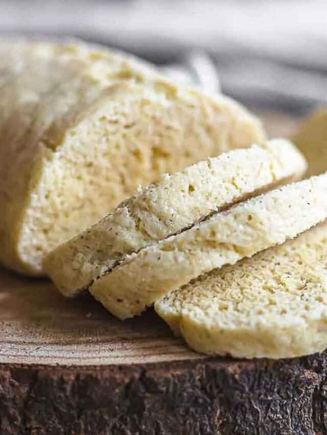 A slice of bread on a wooden cutting board.