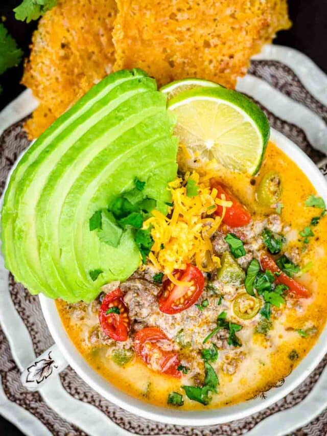 A bowl of mexican soup with tortilla chips.