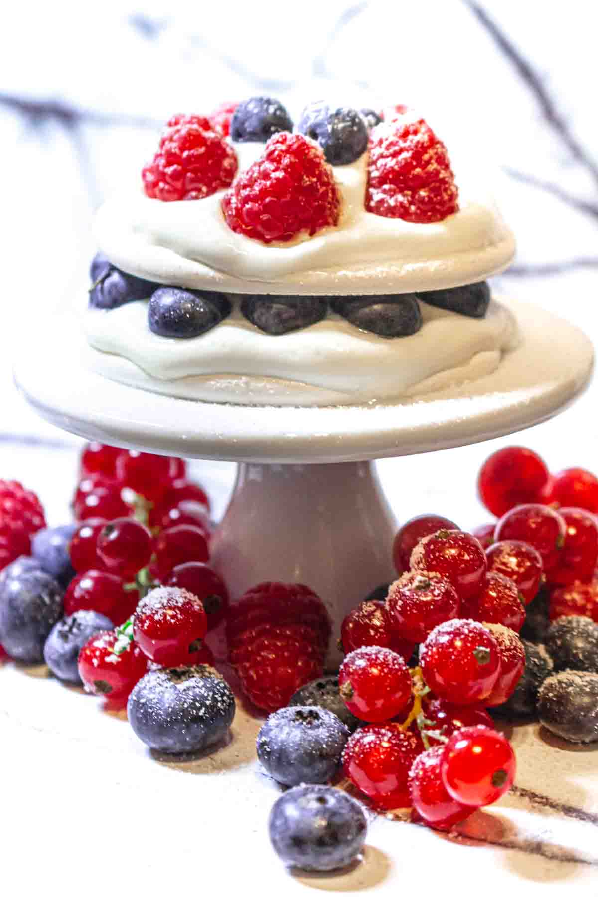 A cake topped with berries and whipped cream.