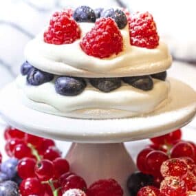 A cake topped with berries and whipped cream.