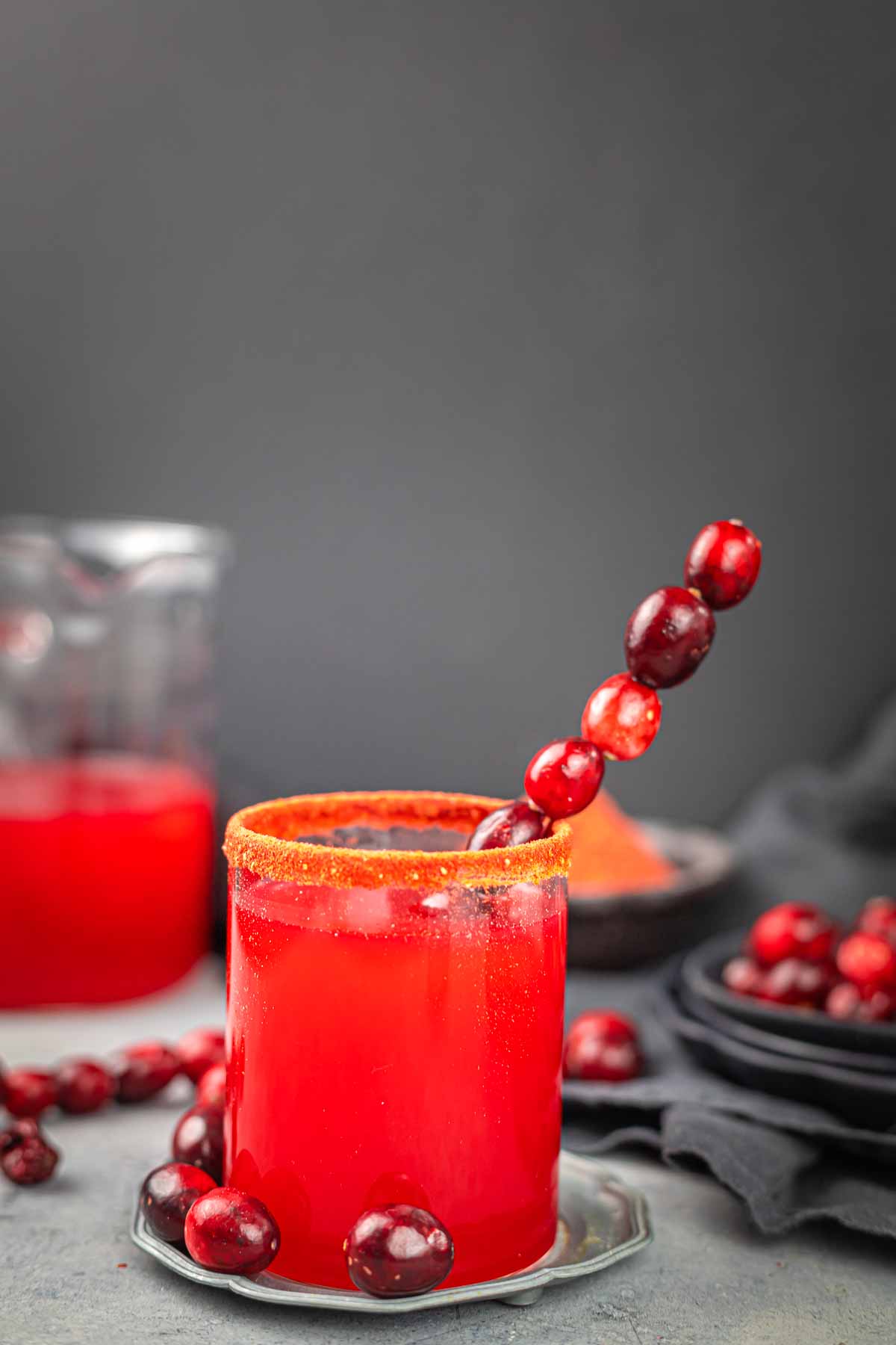 A cranberry juice in a glass with cranberries.