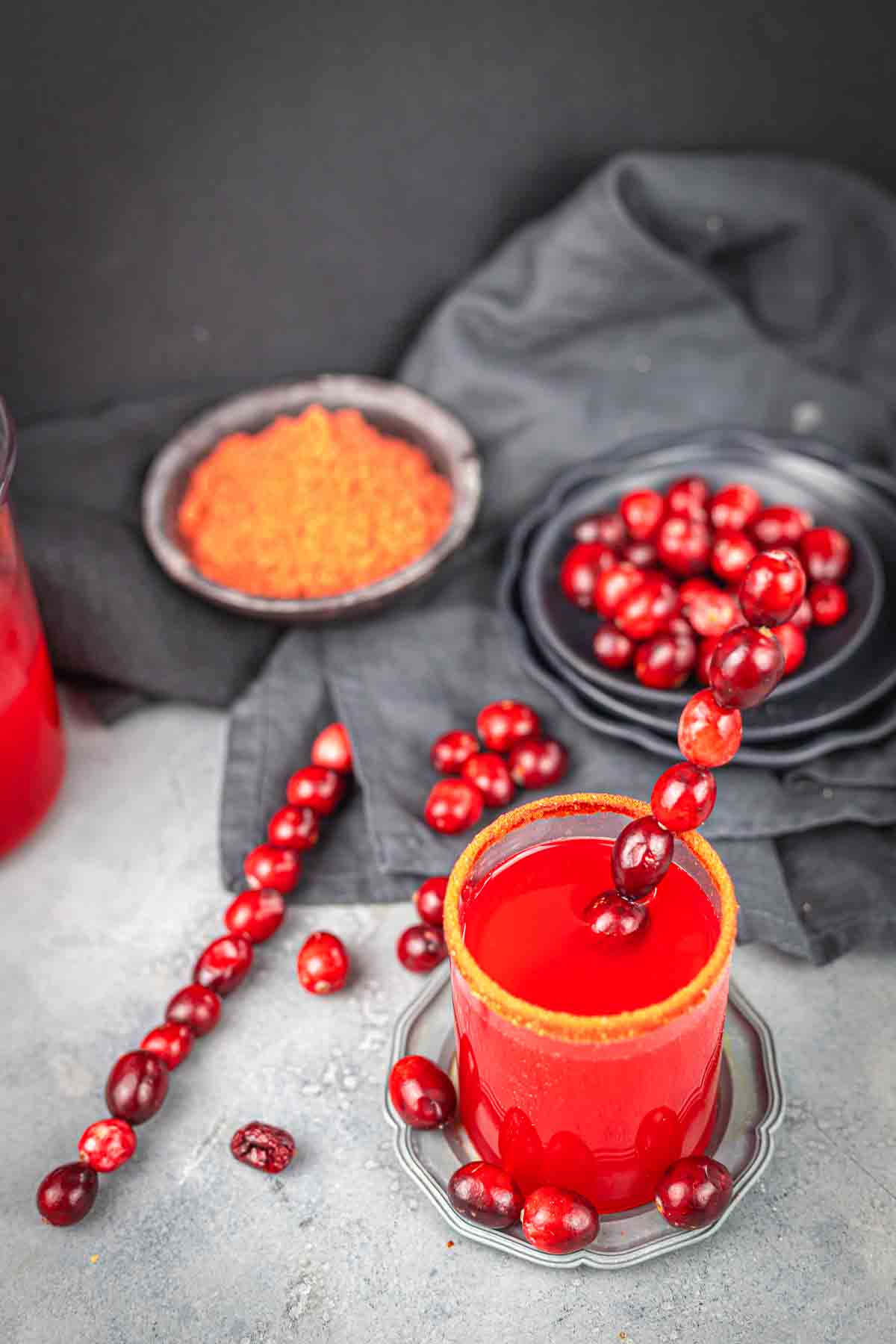 A cup of cranberry juice with cranberries in it.