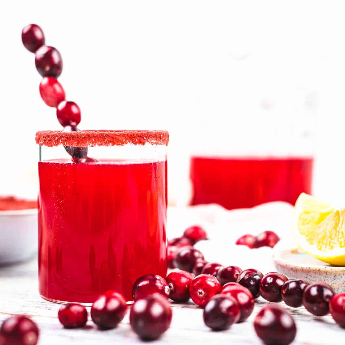 Cranberry juice with lemon wedges and cranberries.