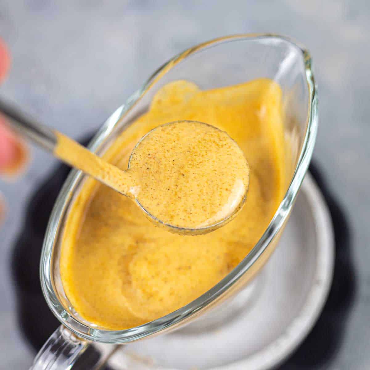 A person is pouring a Worcestershire sauce into a bowl.