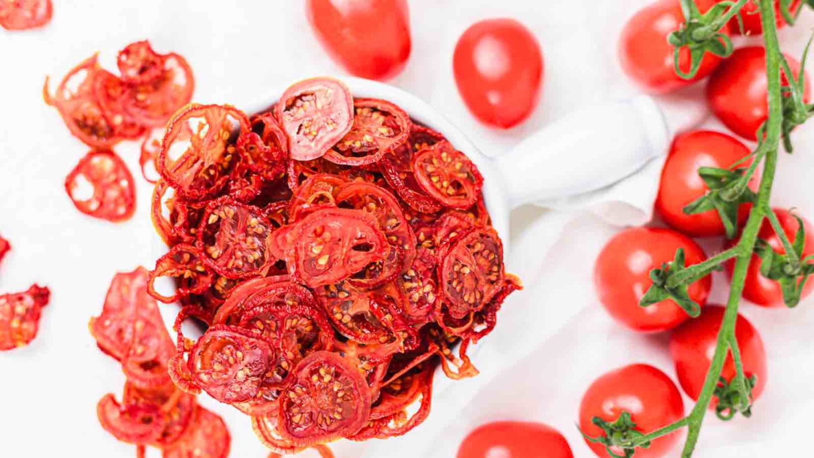Dried tomatoes in a bowl on a white surface.