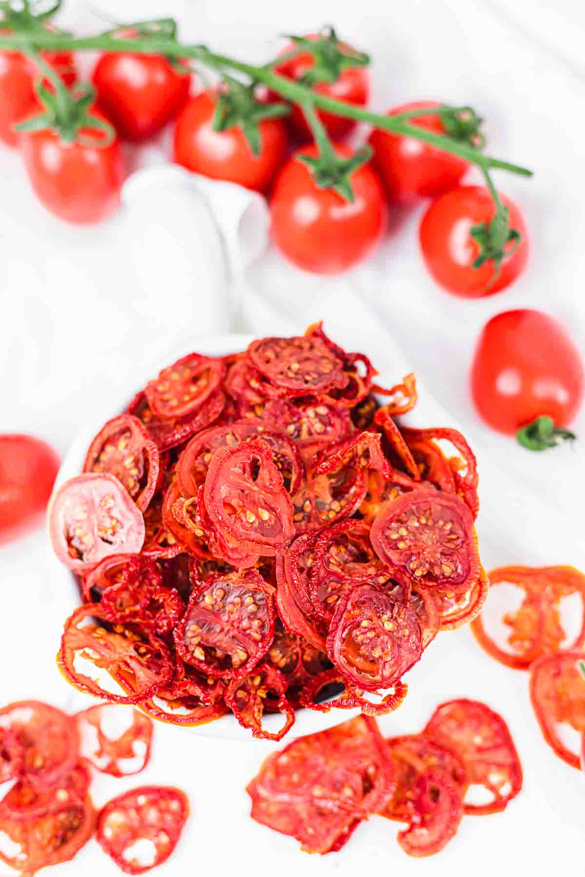 Dried tomato chips on a white table.